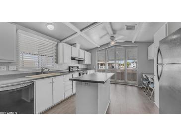 Bright kitchen with white cabinetry, island, and lots of natural light from the large window at 8103 E Southern Ave # 205, Mesa, AZ 85209