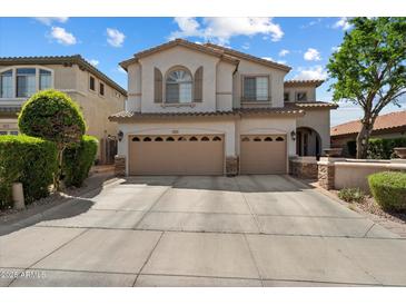 Charming two-story stucco home with a three-car garage, desert landscaping, and a tile roof at 9843 E Acacia Dr, Scottsdale, AZ 85260