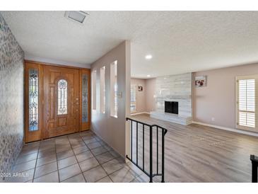 Inviting home foyer with a solid wood front door, tile floors, and a glimpse of the living room at , Glendale, AZ 85302