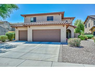 Charming two-story home featuring a three car garage, desert landscaping, and a beautiful tile roof at 15953 W Custer Ln, Surprise, AZ 85379