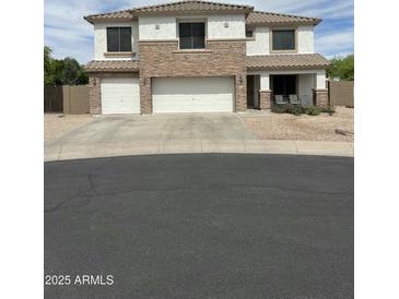 Inviting two-story home featuring a three-car garage and charming front porch at 1849 S 225Th Dr, Buckeye, AZ 85326