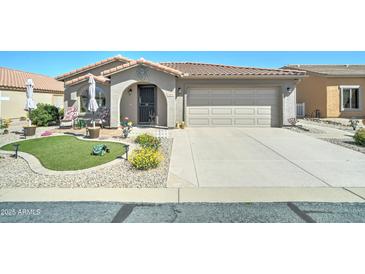 Charming home featuring desert landscaping, a two-car garage, and a welcoming arched entryway and covered porch at 2101 S Meridian Rd # 146, Apache Junction, AZ 85120