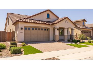 Charming single-story home featuring a tile roof, paver driveway, and manicured landscaping at 23163 E Canary Way, Queen Creek, AZ 85142