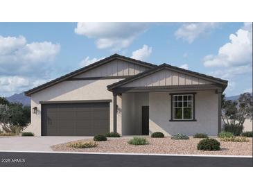 Beautiful single-story home with a neutral-colored exterior, dark gray trim, a front-facing two car garage, and gravel landscaping at 24083 W Bowker St, Buckeye, AZ 85326