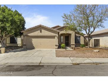 Charming single-story home with a well-maintained lawn, a two-car garage, and desert landscaping at 2932 N 115Th Ln, Avondale, AZ 85392