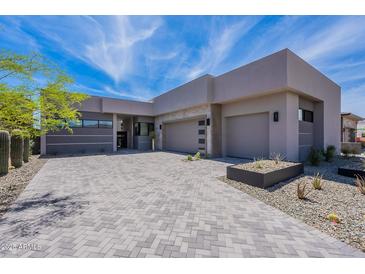 Stunning desert home featuring a modern design, neutral tones, and a spacious driveway with desert landscaping at 37200 N Cave Creek Rd # 1019, Scottsdale, AZ 85262