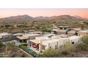 Luxury home with a pool and patio, set against a backdrop of mountains and a golf course at 37200 N Cave Creek Rd # 1034, Scottsdale, AZ 85262