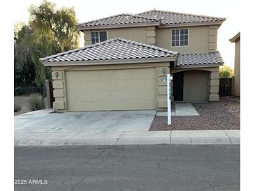Two-story home featuring a 2-car garage, desert landscaping, and a tile roof at 4136 N 113Th Dr, Phoenix, AZ 85037