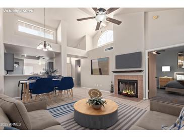 Bright living room featuring a fireplace, ceiling fan, and dining area at 6734 S Brittany S Ln, Tempe, AZ 85283