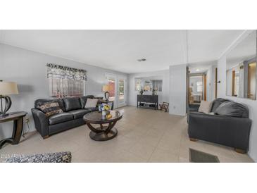 Inviting living room featuring cozy seating, a round coffee table, and access to the outdoor patio at 8103 E Southern Ave # 154, Mesa, AZ 85209