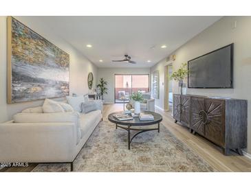 Bright living room features a comfortable couch, stylish decor, and sliding doors to the outdoor patio at 12222 N Paradise Vlg S Pkwy # 237, Phoenix, AZ 85032