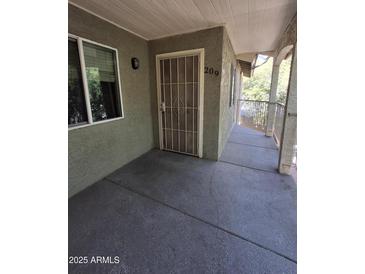 Covered entryway featuring security door, unit number, and access to outdoor walkway at 1336 E Mountain View Rd # 209, Phoenix, AZ 85020