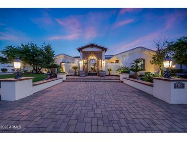 Stunning home exterior featuring a brick driveway and an elegant entrance with manicured landscaping at 1423 E Beverly Ln, Phoenix, AZ 85022