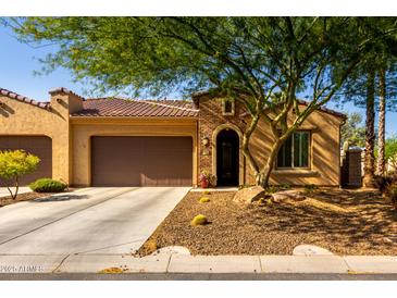 Charming single-story home with tile roof, arched entryway, and well-maintained desert landscaping at 16906 W Palm Ln, Goodyear, AZ 85395