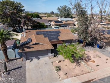 Charming single-Gathering home with desert landscaping and solar panels on the roof at 1720 E Intrepid Ave, Mesa, AZ 85204
