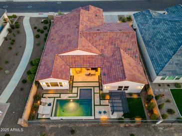 Aerial view of the backyard with a refreshing pool, pergola, and manicured landscaping at 17396 W Crawfordsville Dr, Surprise, AZ 85388