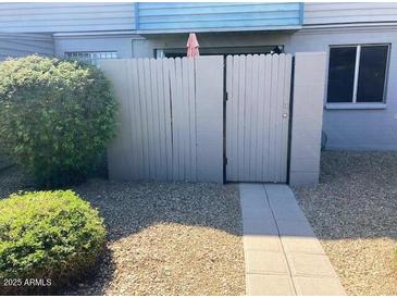Exterior view of home featuring a private courtyard with a privacy fence and desert landscaping at 2602 W Berridge Ln # C102, Phoenix, AZ 85017