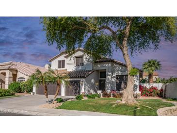 Charming home features a three-car garage, well-manicured lawn, and mature landscaping at 3411 S Vine St, Chandler, AZ 85248