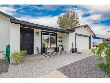 Charming single story home with a neutral color scheme, covered entrance, and two-car garage at 4839 W Juniper Ave, Glendale, AZ 85306