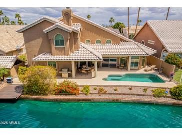 Inviting backyard with a private pool, covered patio, and direct access to the serene waterfront at 518 S Bay Shore Blvd, Gilbert, AZ 85233