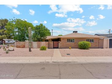 Charming single-story home featuring a brick facade and well-manicured desert landscaping at 8202 E Coolidge St, Scottsdale, AZ 85251