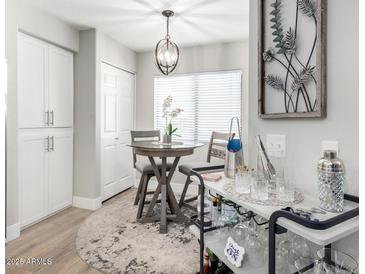 Bright dining area featuring a round table, bar cart, and modern decor with white cabinets and natural light at 15252 N 100Th St # 1154, Scottsdale, AZ 85260