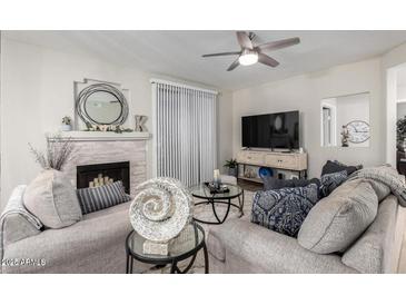 Cozy living room featuring a fireplace, ceiling fan, and neutral decor, perfect for relaxing and entertaining guests at 15252 N 100Th St # 1154, Scottsdale, AZ 85260
