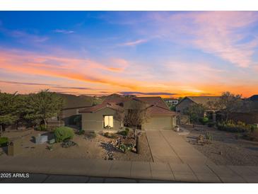 Charming desert home features a tile roof, mature landscaping, and a welcoming two-car garage at 7145 E Cuernavaco Way, Gold Canyon, AZ 85118