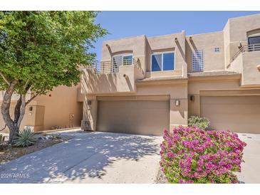 South Scottsdale two-story townhome with a two-car garage, balcony, desert landscaping and block construction at 11752 N 135Th Pl, Scottsdale, AZ 85259