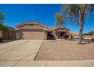 Charming single-story home boasts a well-maintained front yard, two-car garage, and a welcoming entrance at 14514 N 128Th Dr, El Mirage, AZ 85335