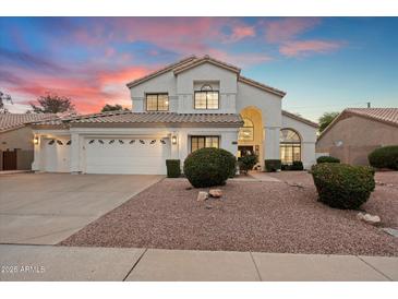 Charming two-story home featuring a well-manicured front yard with mature landscaping and a three car garage at 14862 N 90Th Pl, Scottsdale, AZ 85260