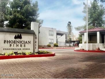 A view of the entrance to the Phoenician Pines Condominium Homes, surrounded by lush landscaping at 3420 W Danbury Dr # C130, Phoenix, AZ 85053