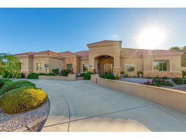 Stunning home with a circular driveway, beautiful landscaping, and a grand entrance, perfect for luxurious living at 35662 N Creekside Ln, Queen Creek, AZ 85144