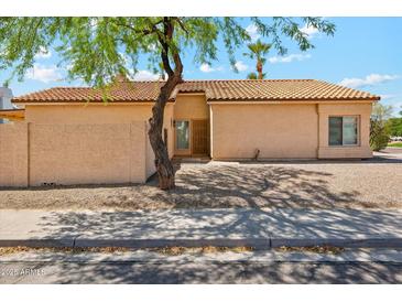 Charming single-story home with a well-maintained desert landscape and a classic tile roof at 4353 E Desert Wind Dr, Phoenix, AZ 85044