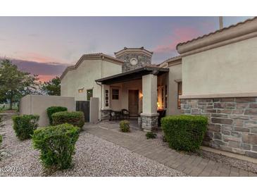 Inviting front entrance featuring stone accents, a covered porch, and lush landscaping at 6202 E Mckellips Rd # 65, Mesa, AZ 85215