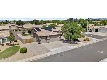 Expansive home features a 3 car garage, desert landscaping, and solar panels for energy efficiency at 1182 E Canyon Way, Chandler, AZ 85249