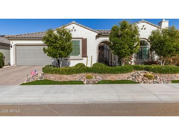 Charming single-story home featuring lush landscaping, beautiful stonework and a neutral-toned exterior at 19215 N 259Th Ave, Buckeye, AZ 85396