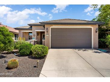 Charming single-story home featuring a well-manicured front yard and a two-car garage at 20523 N 267Th Ln, Buckeye, AZ 85396