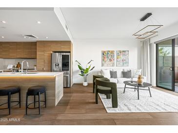 Bright living room featuring hardwood floors and a modern kitchen island with counter seating at 2300 E Campbell Ave # 106, Phoenix, AZ 85016