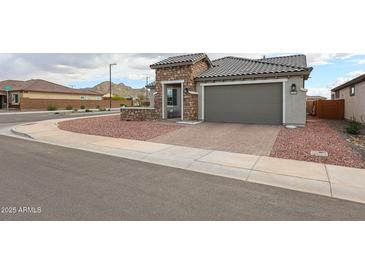 Charming single-story home featuring a stone facade and a well-manicured, low-maintenance landscape at 27053 W Ponderosa Ln, Buckeye, AZ 85396