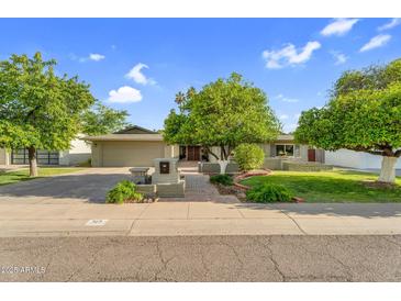 Charming single-story home boasts mature trees, a well-manicured lawn, and inviting curb appeal at 315 E Marlette Ave, Phoenix, AZ 85012