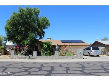 Charming single-story home with a well-kept front yard and solar panels on the roof at 4116 N 78Th Ave, Phoenix, AZ 85033