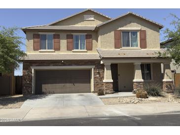 Charming two-story home with a two car garage, stone accents and a well maintained front yard at 6506 S 50Th Ln, Laveen, AZ 85339