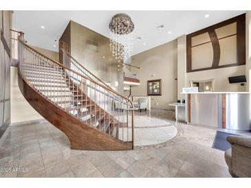 Grand lobby featuring a curved staircase, stylish chandelier, and concierge desk at 945 E Playa Del Norte Dr # 1003, Tempe, AZ 85288