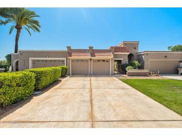 Charming single-story home featuring a large driveway, mature landscaping, and a three-car garage, with a tile roof at 9847 E Michigan Ave, Sun Lakes, AZ 85248