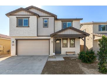 Charming two-story home with landscaped yard, a covered entryway, and an attached two-car garage at 10983 W Mckinley St, Avondale, AZ 85323