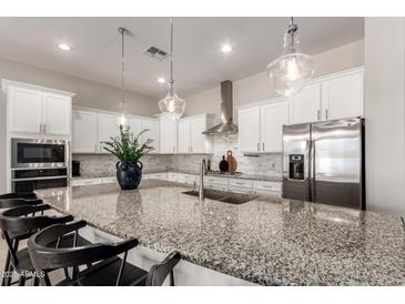 Bright and airy kitchen featuring white cabinets, granite countertops, stainless steel appliances, and pendant lighting at 19038 N Arbor Dr, Maricopa, AZ 85138