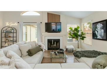 Bright living room with a fireplace, large sectional sofa, modern decor, and ample natural light at 21940 N 69Th Dr, Glendale, AZ 85310