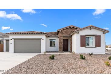 Charming single-story home with a stone accent wall, desert landscaping, and a two-car garage at 37805 W Santa Maria St, Maricopa, AZ 85138