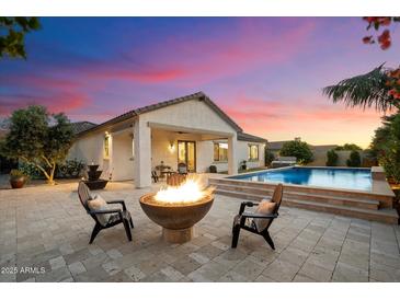 Outdoor living space features a fire pit, pool, and covered patio with seating at 3912 E Ellis St, Mesa, AZ 85205
